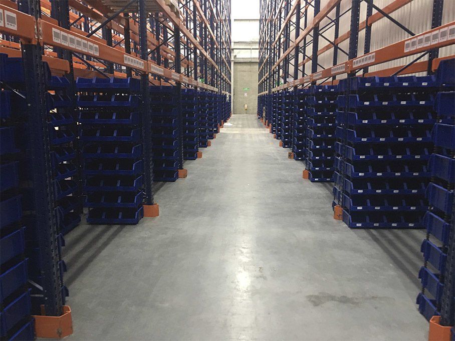 Un almacén lleno de contenedores y estantes azules.