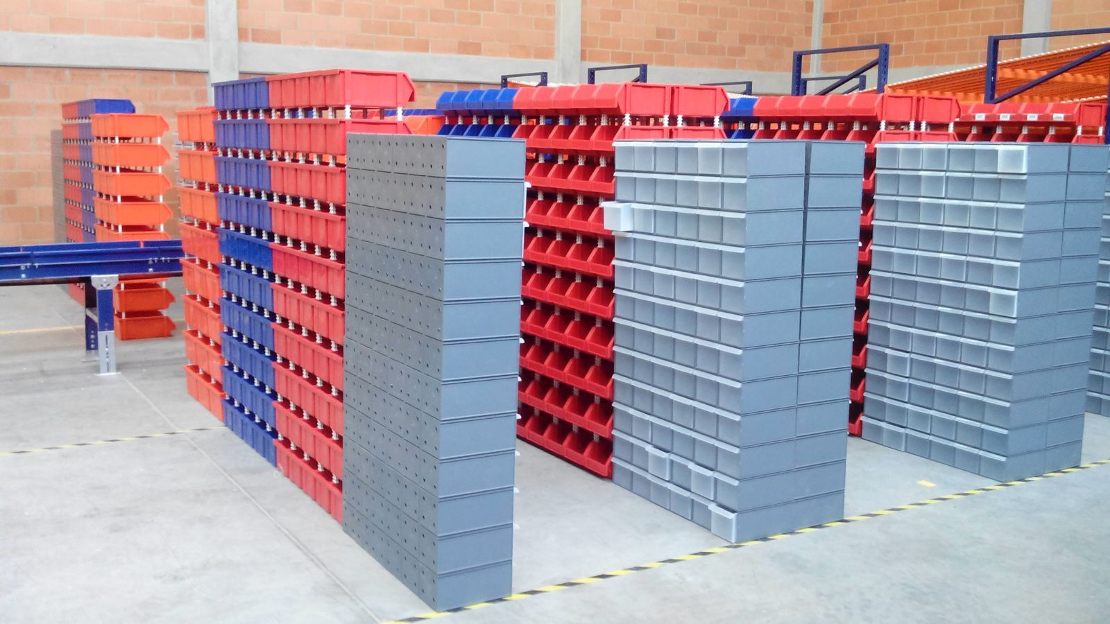 Un almacén lleno de estanterías y contenedores.