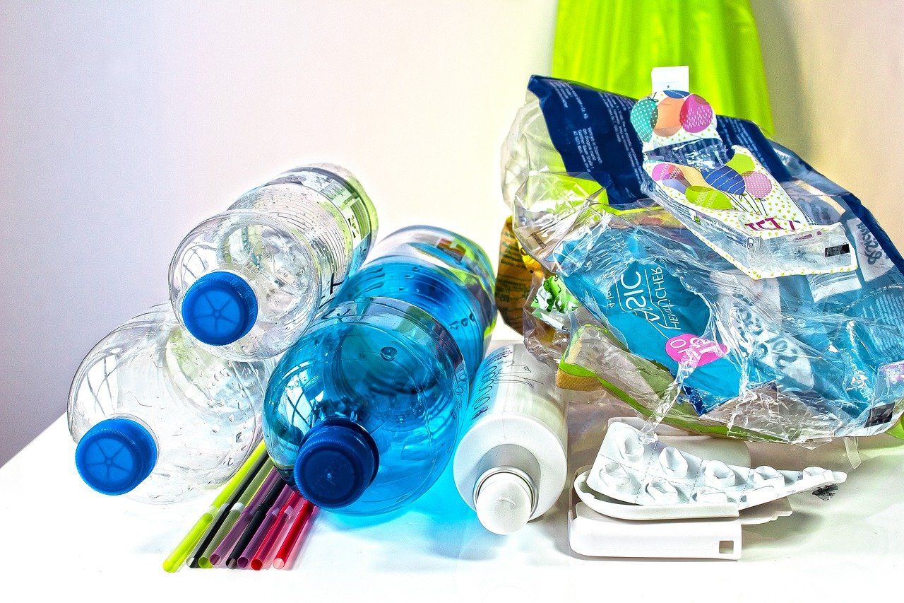 Hay muchos tipos diferentes de botellas de plástico sobre la mesa.