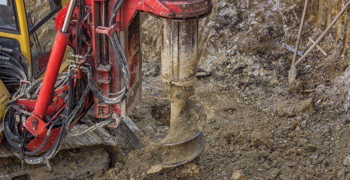 a machine is drilling a hole in the ground .