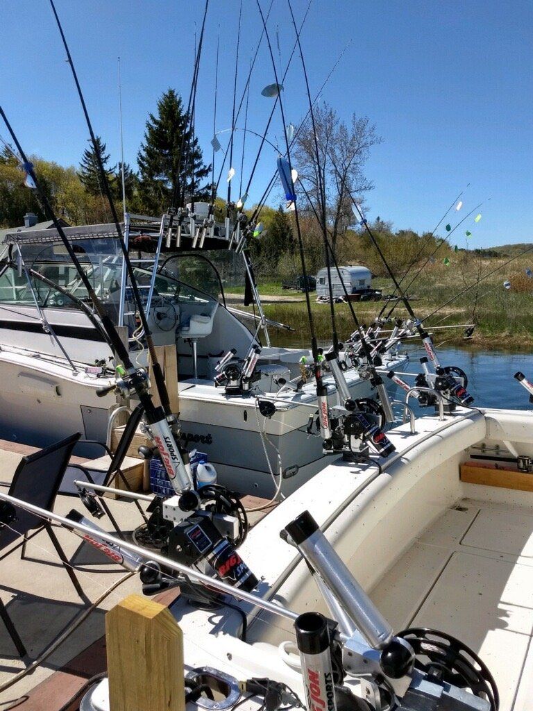 Fishing boats with rods docked at a marina on a sunny day