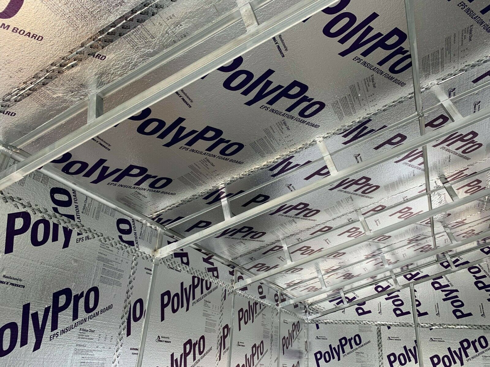 Interior view of a room with reflective PolyPro insulation attached to the walls and ceiling, covering metal studs.