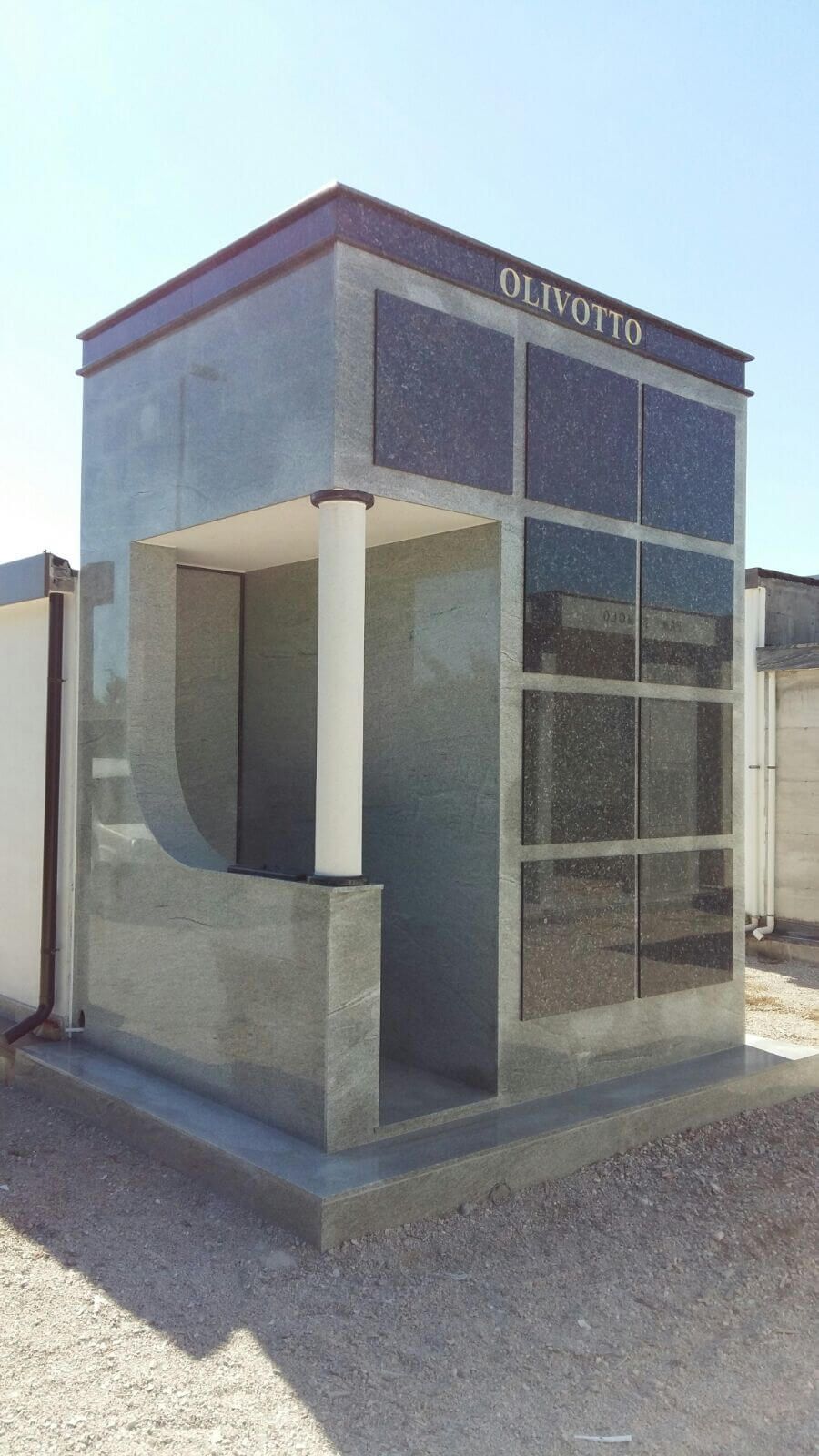 Un piccolo edificio con molte finestre si trova in cima a un campo sterrato.