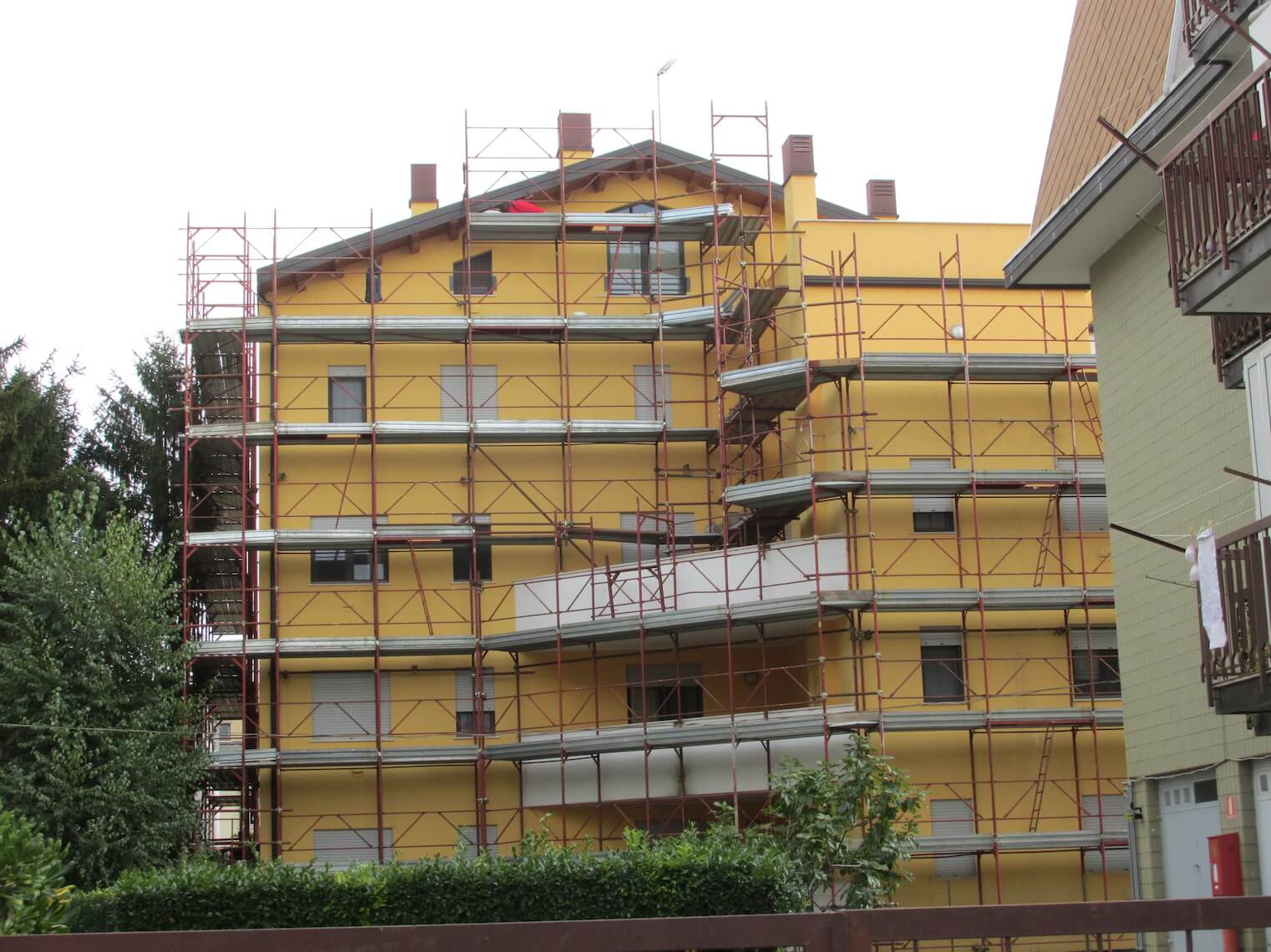 Un grande edificio giallo con impalcature attorno