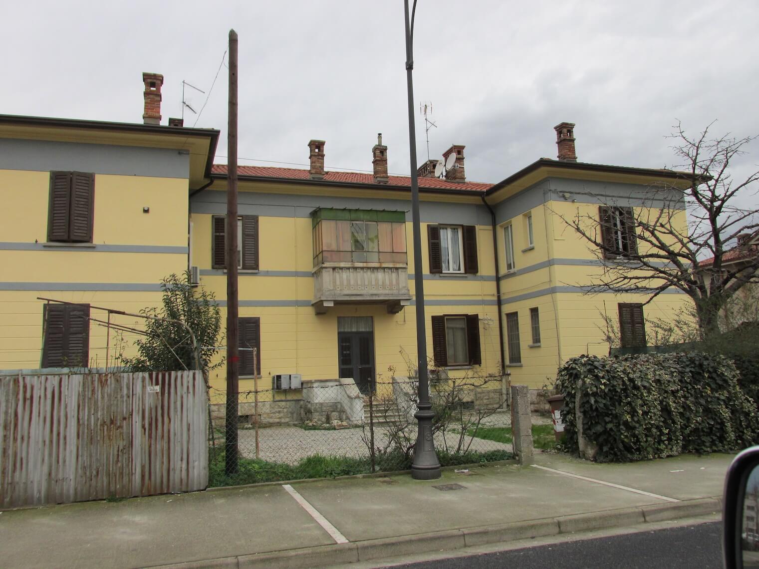 Un edificio giallo con un balcone e un tetto rosso
