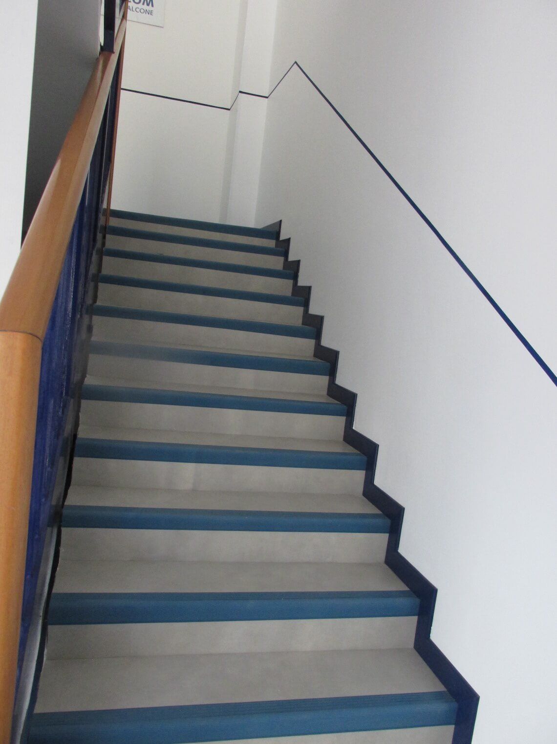 Una serie di scale con gradini blu e una ringhiera in legno