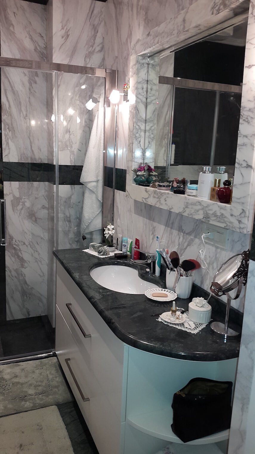 Un bagno con lavandino, specchio e doccia.
