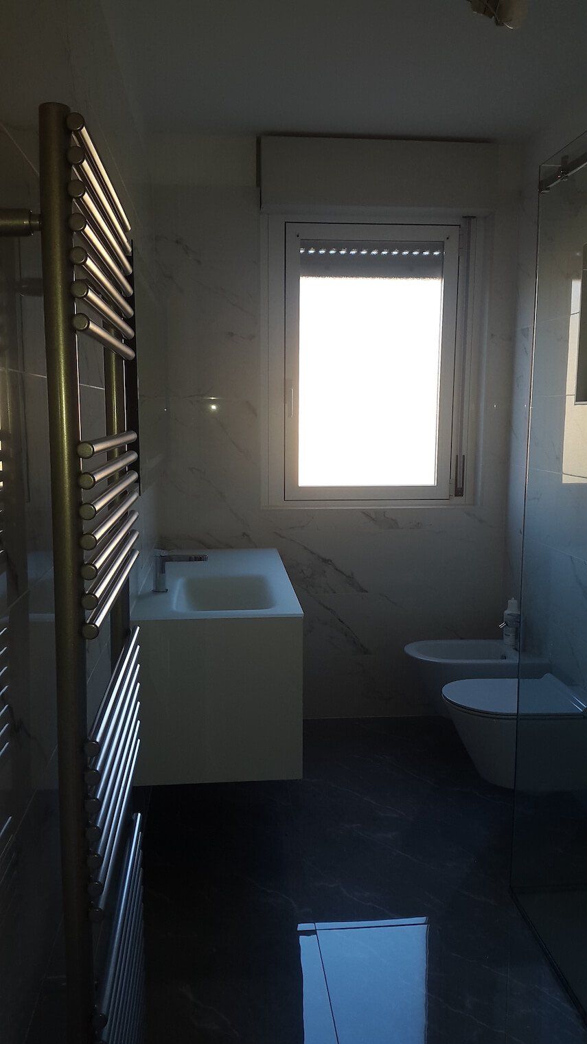 Un bagno con lavandino, water e finestra