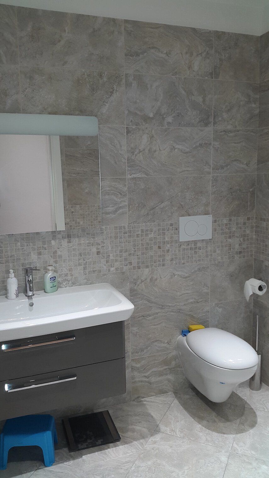 Un bagno con lavandino, water e specchio.