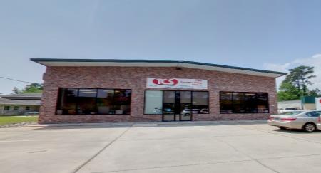 A brick building with a lot of windows and a car parked in front of it.