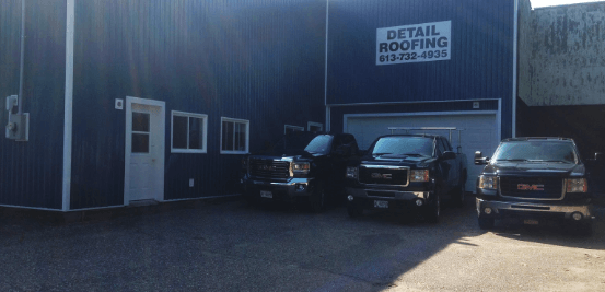 storefront with three pickup trucks parked in front of it