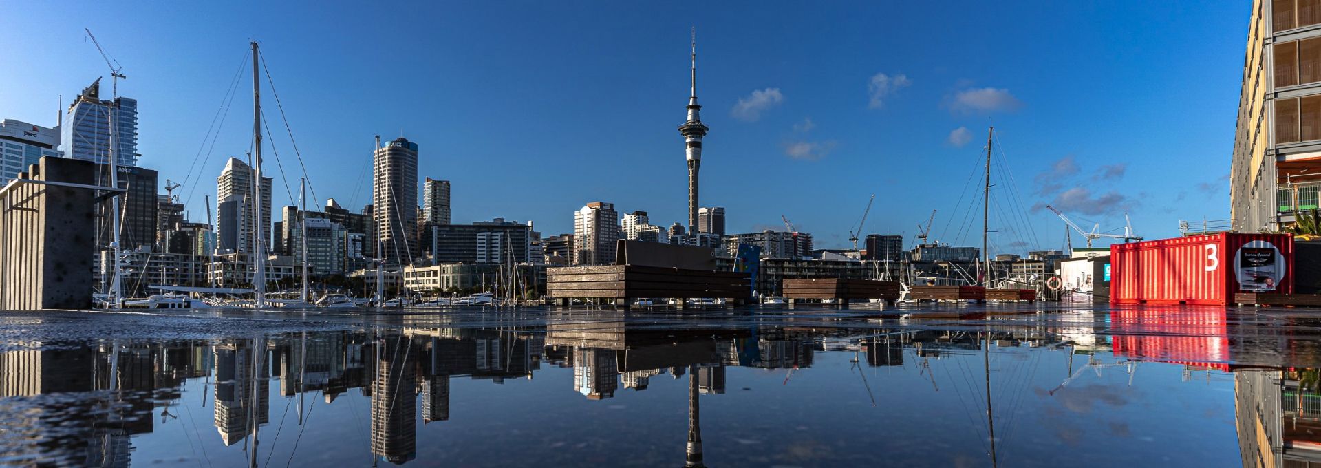 A city skyline is reflected in a body of water.