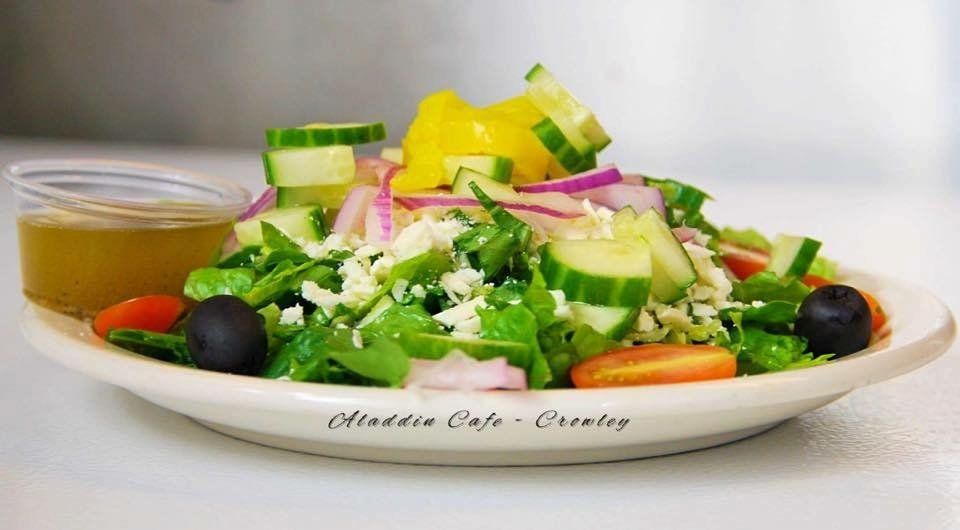 a white plate topped with a salad and a dipping sauce .