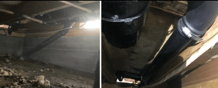 Black plumbing pipes in a crawl space, secured with clamps and sealed.