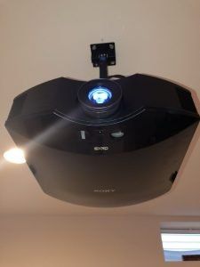 Black Sony projector mounted on a white ceiling.