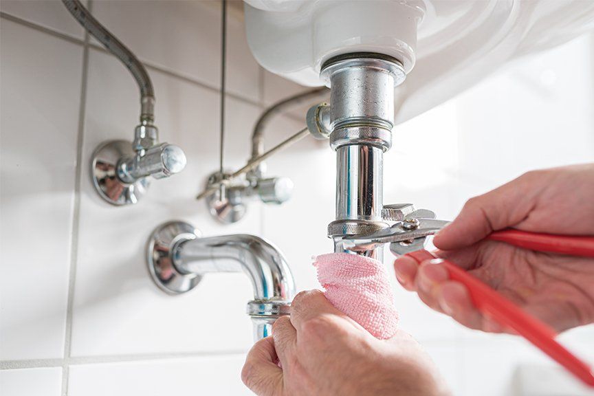 Water Pouring Out of Faucet — Sioux City, IA — Foulk Brothers Plumbing Water heater service being done in Sergeant Bluff, IA