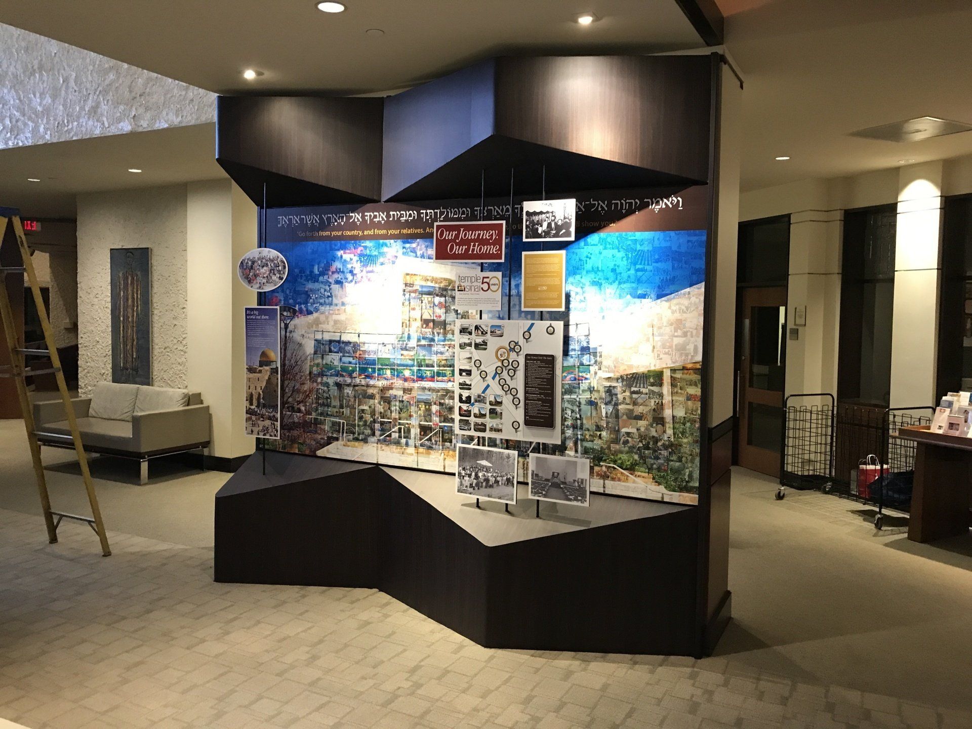 A large display case in a lobby with a ladder in the background.