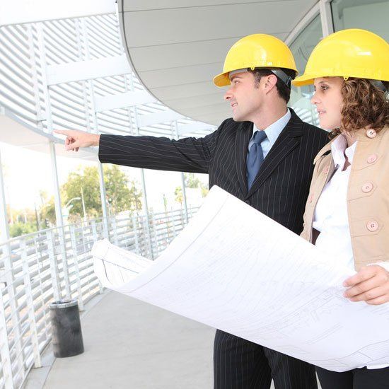 man and woman in builders hats consulting about a design