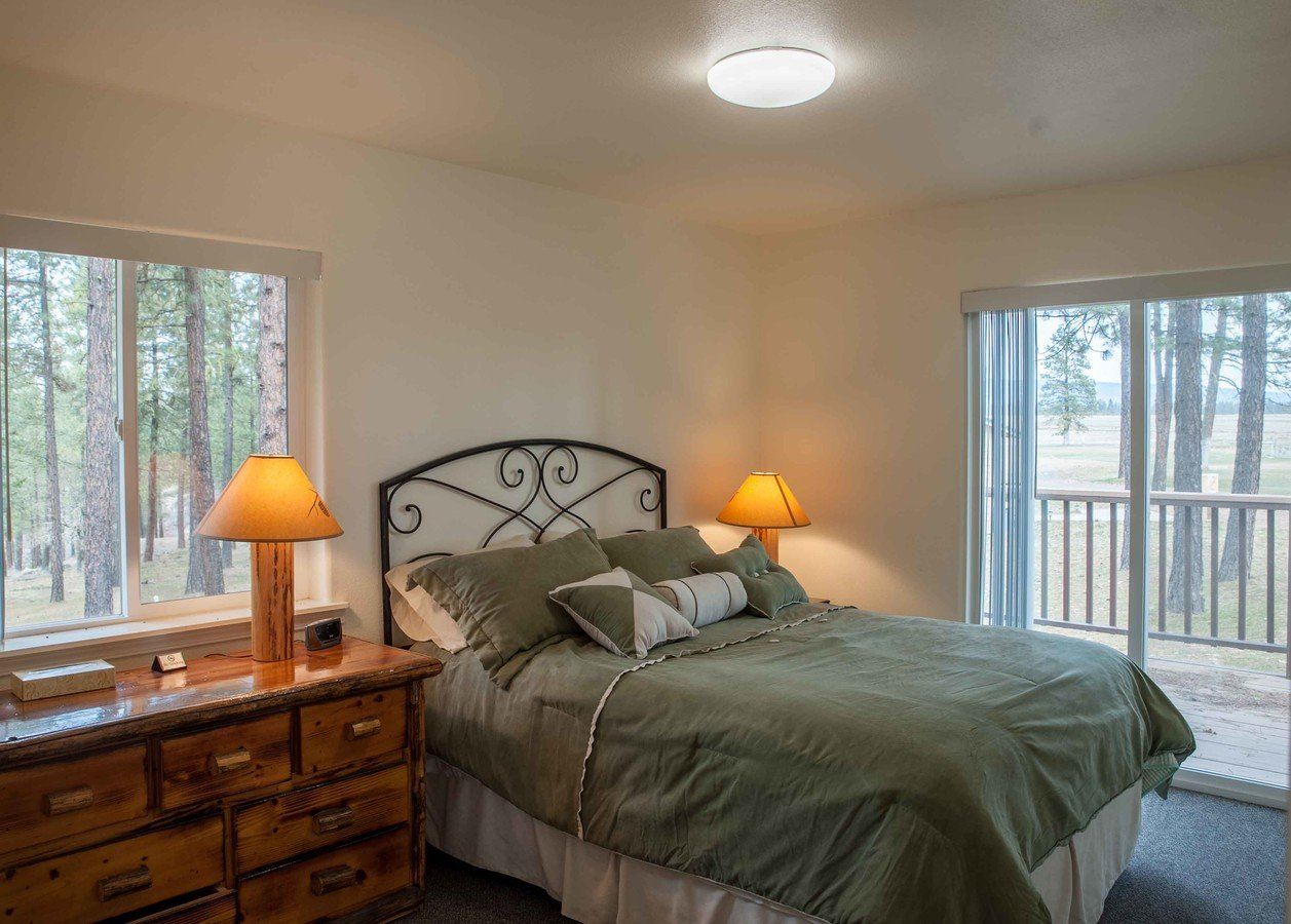 A bedroom with a bed , dresser , and two lamps.