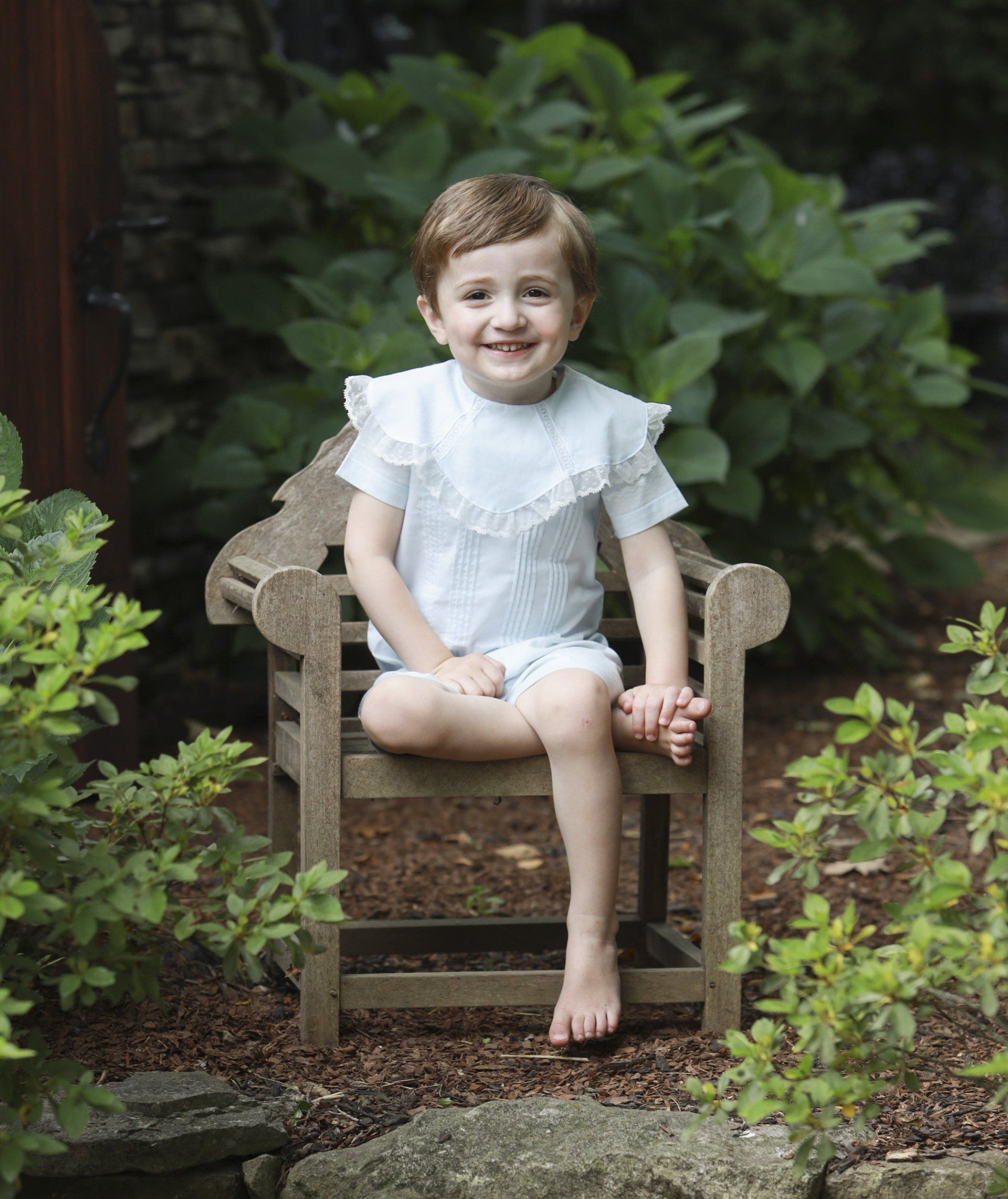 Outdoor portrait of boy sitting in garden