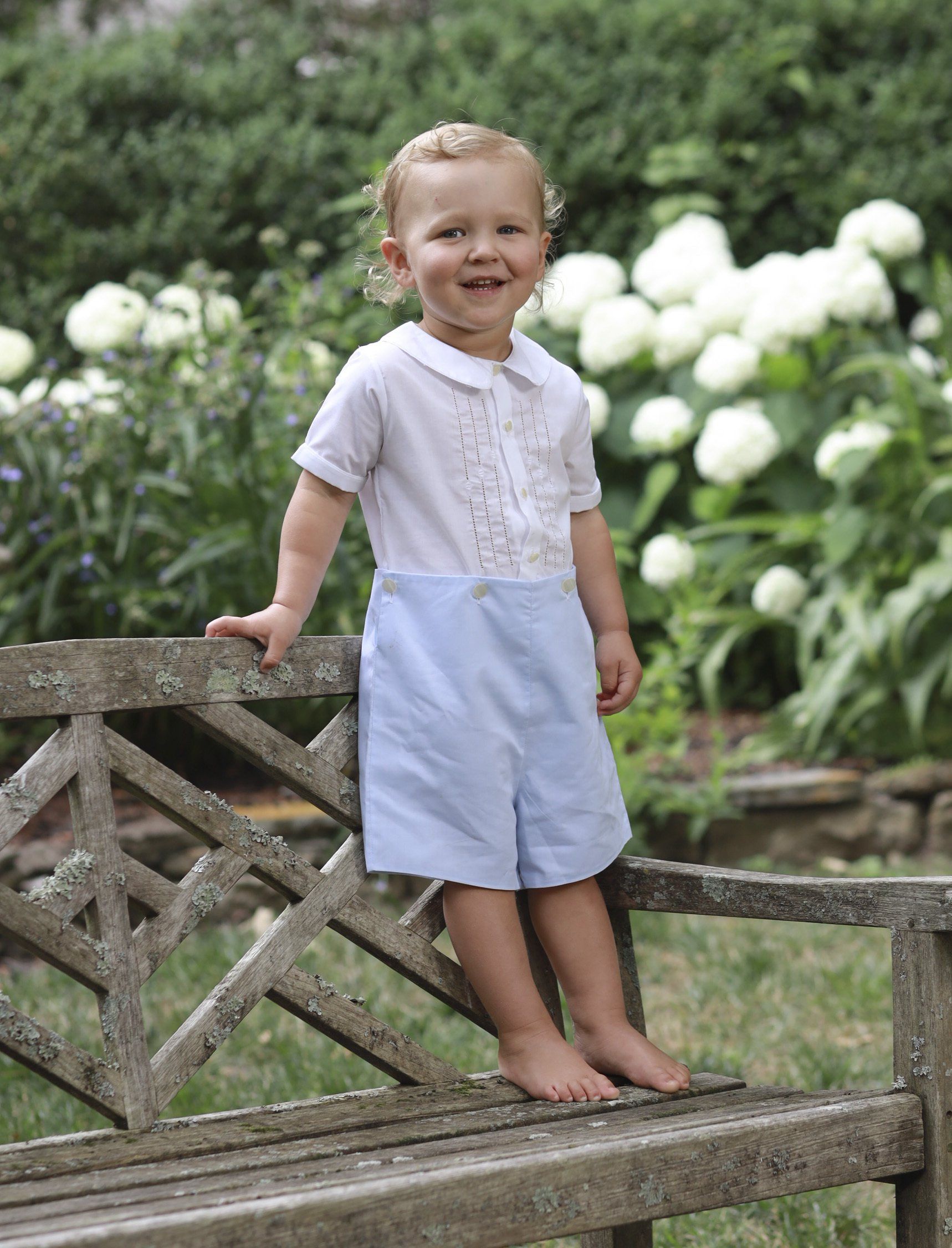 Outdoor portrait of boy in garden with flowers