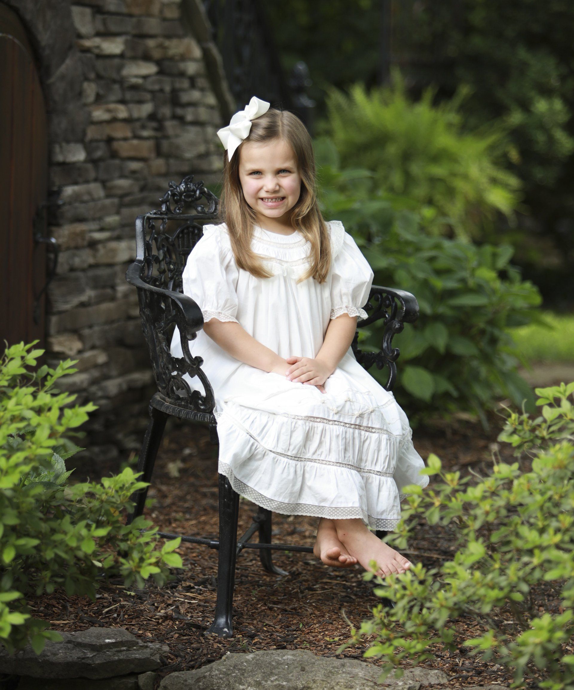 Girl sitting in green gardens by Nashville photographer