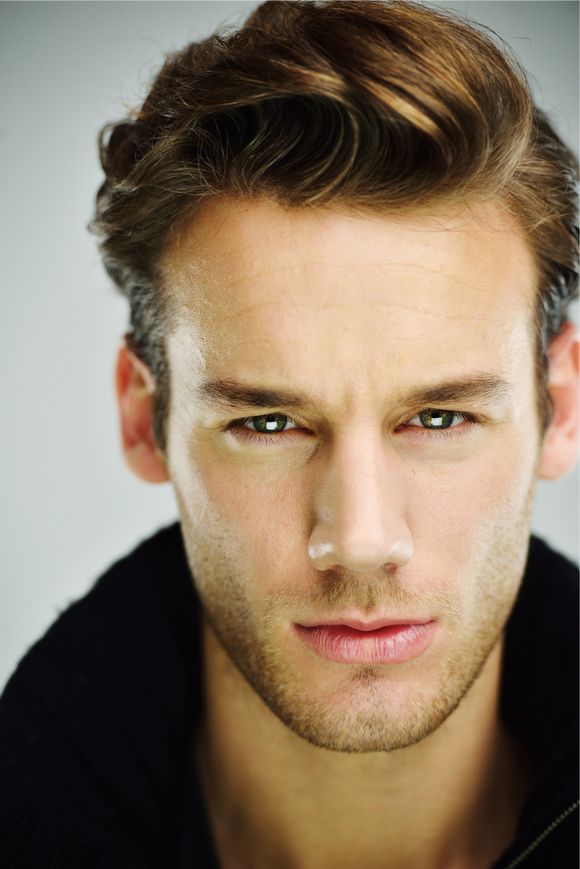 A close up of a man 's face with a beard looking at the camera.