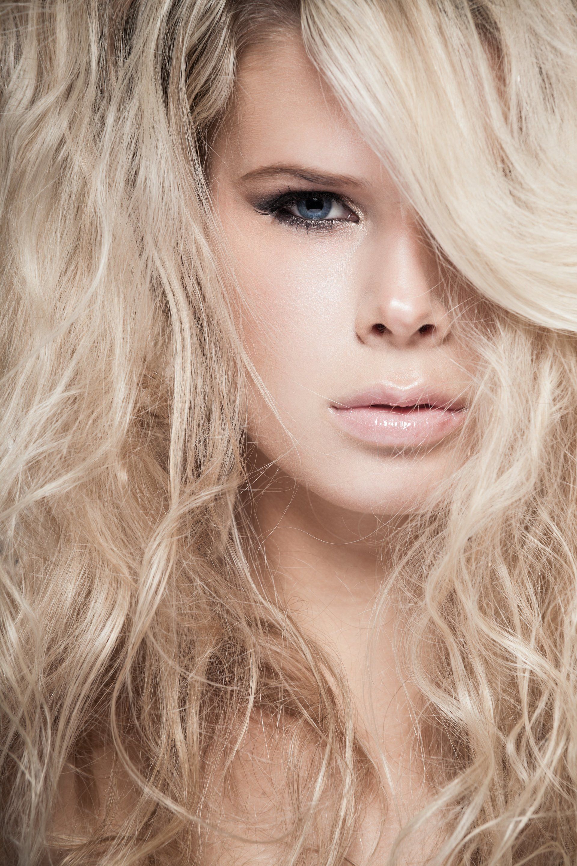 A close up of a woman 's face with long blonde hair.