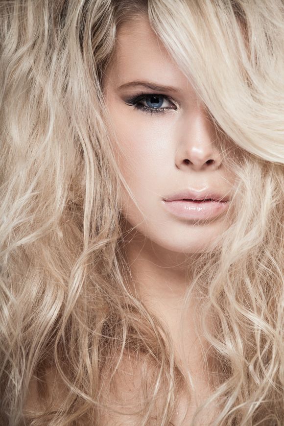 A close up of a woman 's face with long blonde hair.