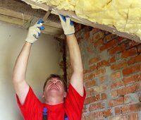 Man Wearing Red Shirt Fixing the Insulation — Travelers Rest, SC — Guy M Beaty Co Man Wearing Red Shirt Fixing the Insulation — Travelers Rest, SC — Guy M Beaty Co