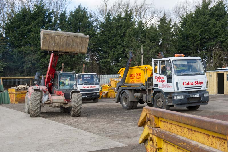 vehicles carrying skips of different sizes