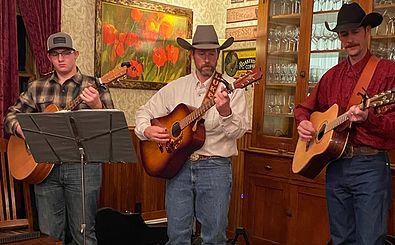 A group of men are playing guitars in a room.