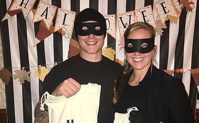 A man and a woman wearing masks are posing for a picture.