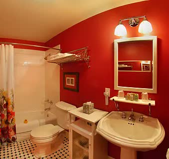 A bathroom with red walls , a sink , toilet and bathtub