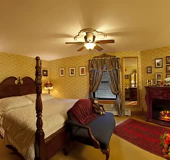 A bedroom with a four poster bed and a ceiling fan