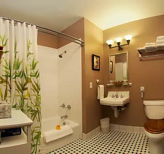 A bathroom with a tub , sink , toilet and mirror.
