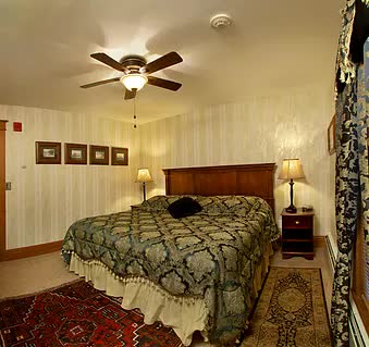 A bedroom with a bed and a ceiling fan