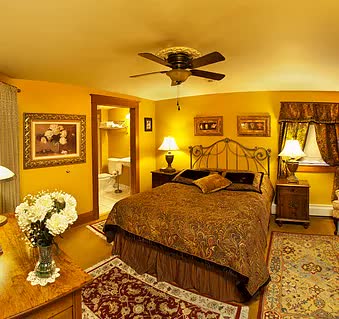 A bedroom with a large bed and a ceiling fan