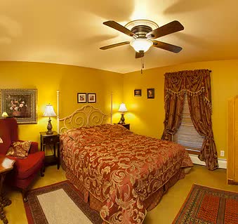 A bedroom with a bed and a ceiling fan