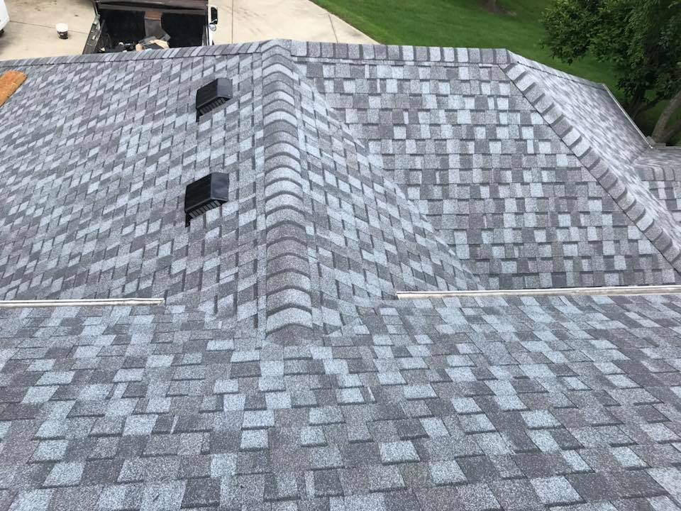 Gray shingle roof with two black vents and a ridge line, viewed from above