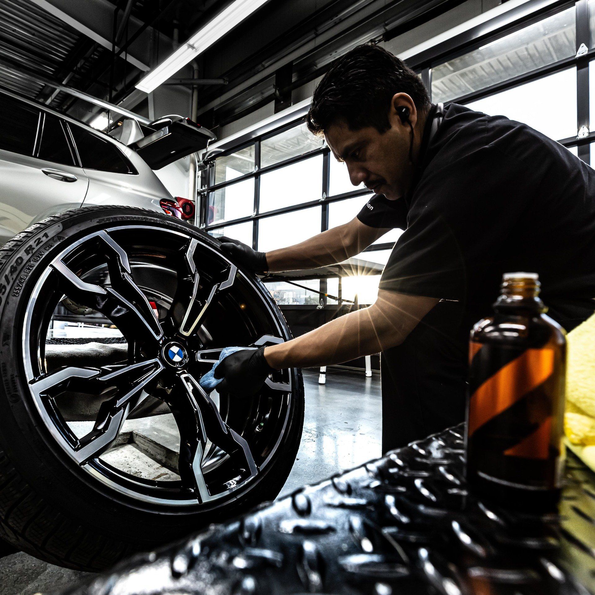 A man is working on a car wheel in a garage.