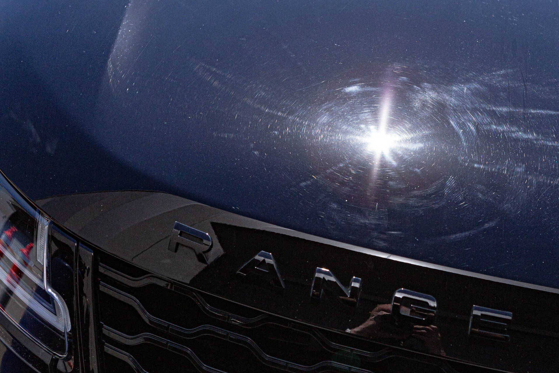 A close up of a range rover hood with the sun shining through it