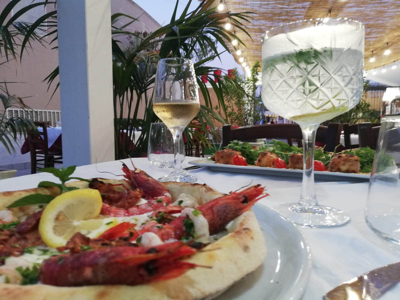 pizza con gamberi e calice di vino