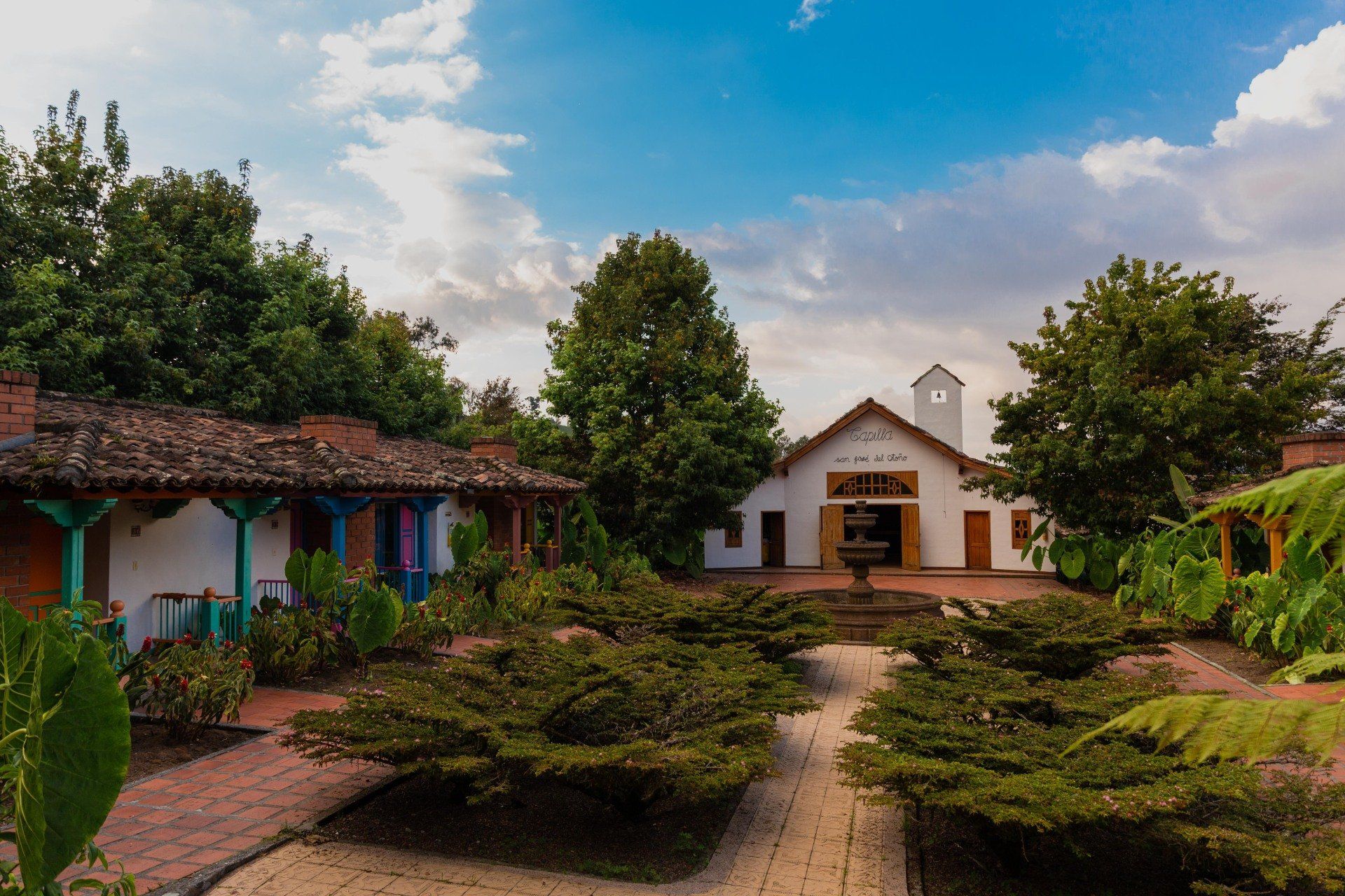 White chapel at Termales El Otoño Hotel for weddings in Manizales, featuring a classic facade and entrance.