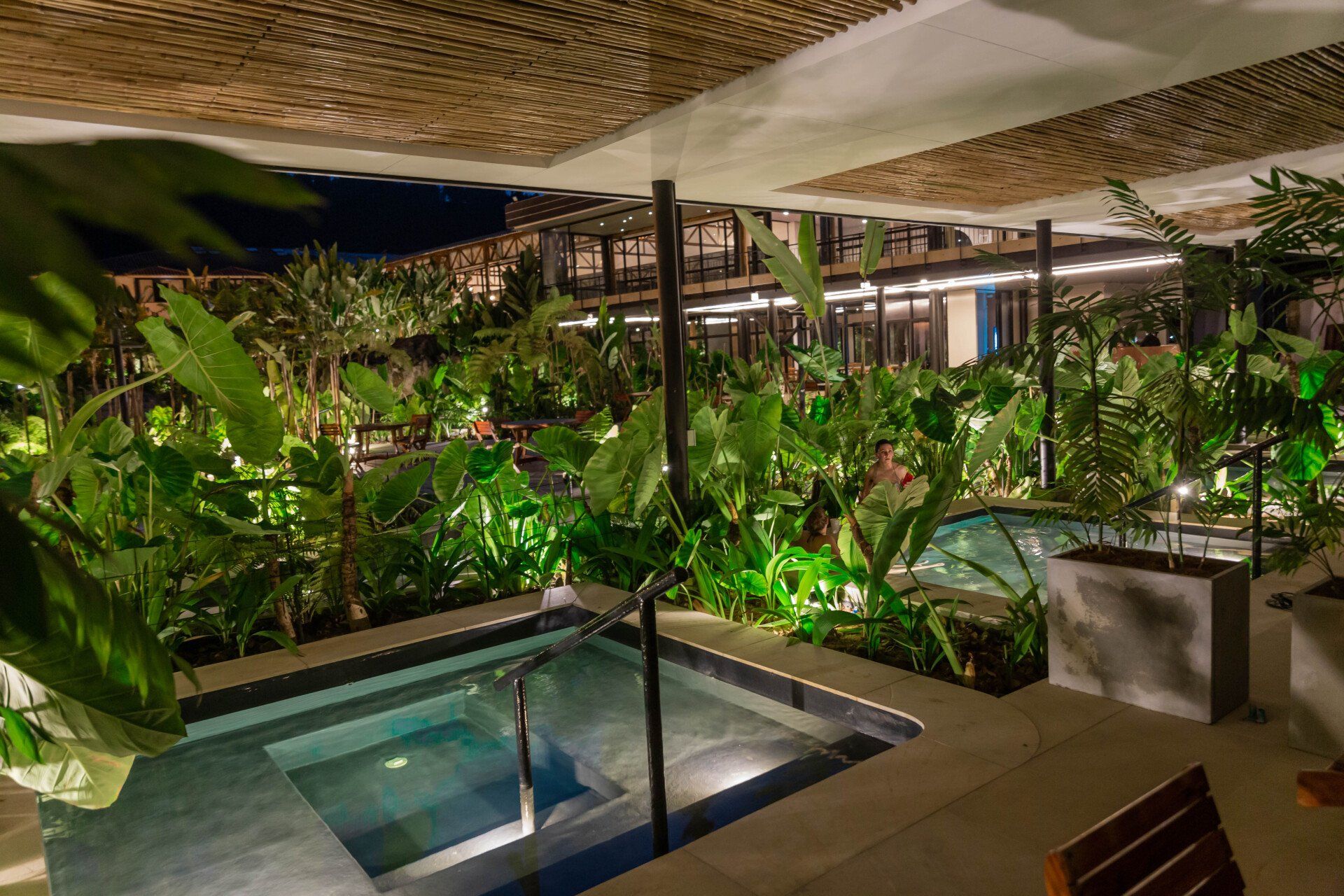 VIP thermal pools at Termales El Otoño, featuring small hot spring pools, warm lighting, and surrounding tropical vegetation