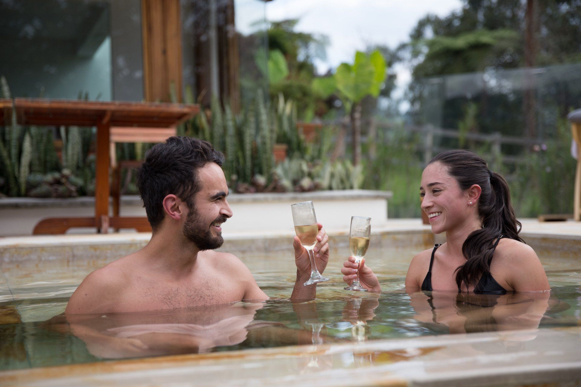 Couple toasting in thermal pools at Termales El Otoño, a relaxing wellness experience near Manizales.