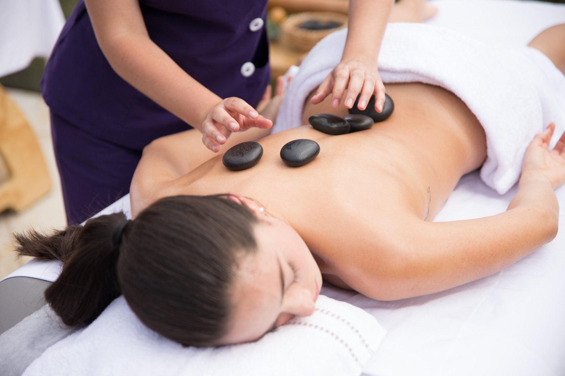 Hot stone massage on a woman’s back, a relaxation and wellness experience at Termales El Otoño.