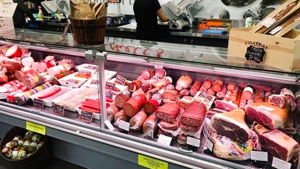 A butcher 's display case filled with lots of meat and sausages.