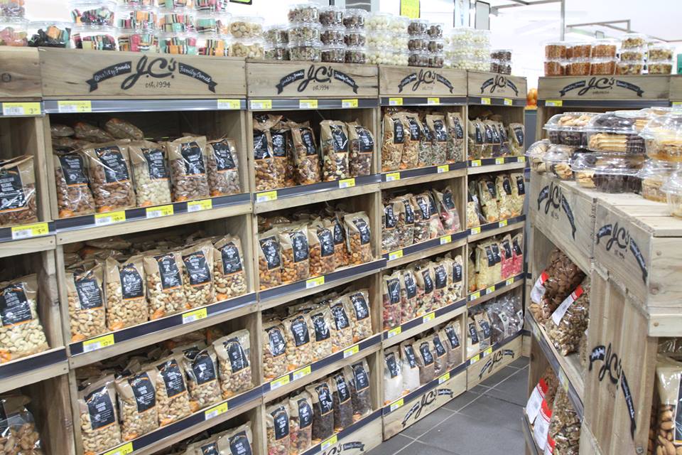 Store aisle filled with lots of bags of nuts