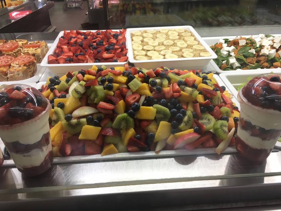 A variety of fruit salads and desserts displayed on a counter